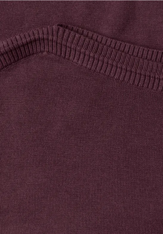 Gros plan sur un tissu bordeaux avec couture renforcée