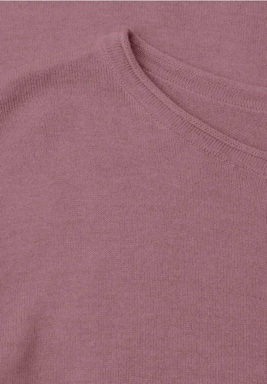 Close-up van een lichtroze T-shirt met ronde hals en fijn gebreide stof.