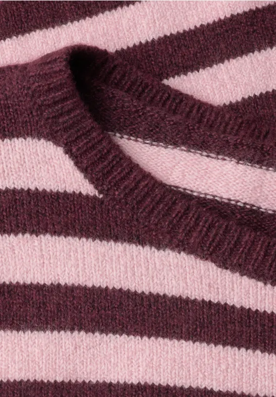 Nahaufnahme eines gestrickten Pullovers mit rosa und weinroten Querstreifen.