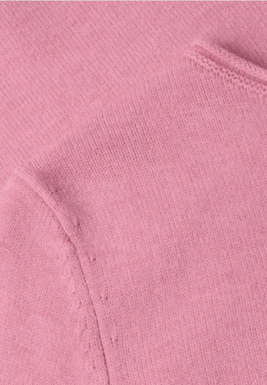 Nahaufnahme von rosafarbenem Sweatshirtstoff mit Nähnaht und Taschelement.