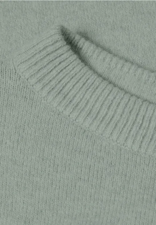 Gros plan d'un pull en maille vert pâle/gris clair avec col rond côtelé.