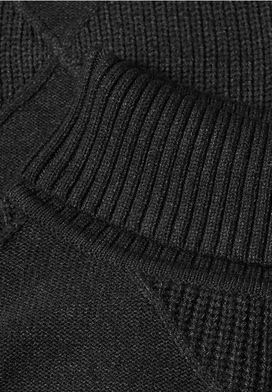 Close-up van zwart geribd gebreid textiel.
