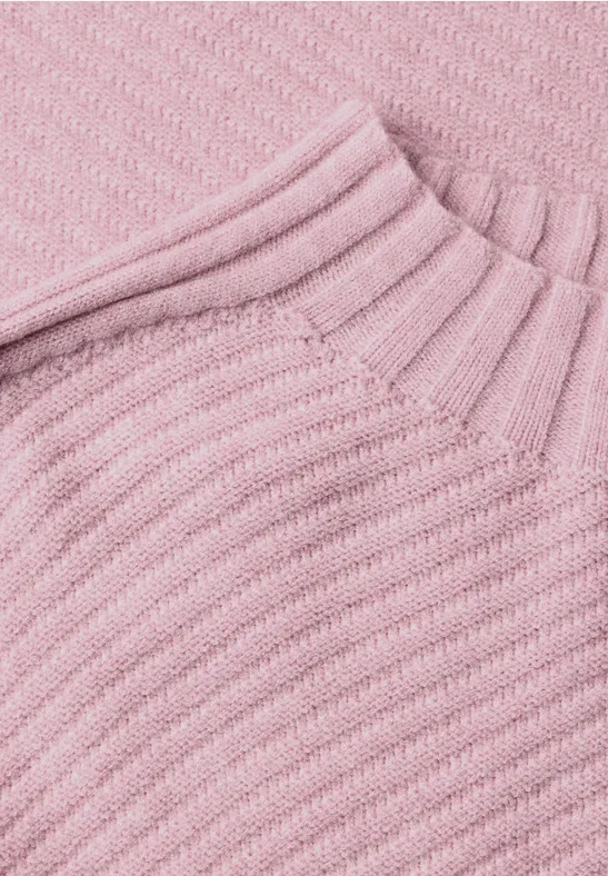 Nahaufnahme eines rosa, gerippten Strickpullover-Stoffs
