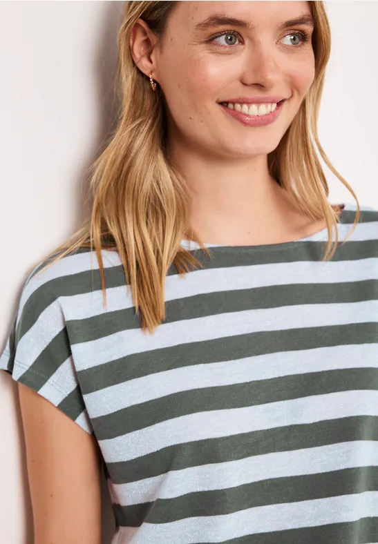 Een blonde vrouw draagt een kort mouwtop met groene en witte strepen.