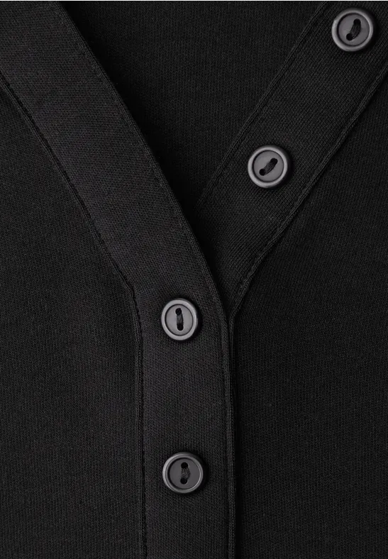 Nahaufnahme eines schwarzen Cardigans mit schwarzer Knopfleiste