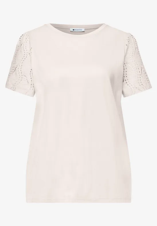 Een eenvoudig crèmekleurig T-shirt met korte mouwen van kant.