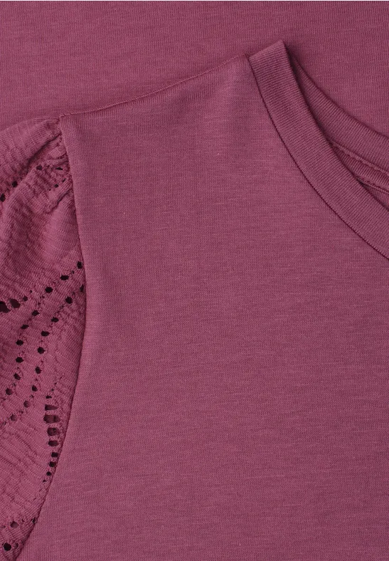 Ein lila Oberteil mit Spitzendetail am kurzen Ärmel.