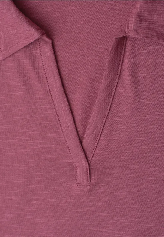 Close-up van een fuchsia roze T-shirt met V-hals en vlakke kraag.