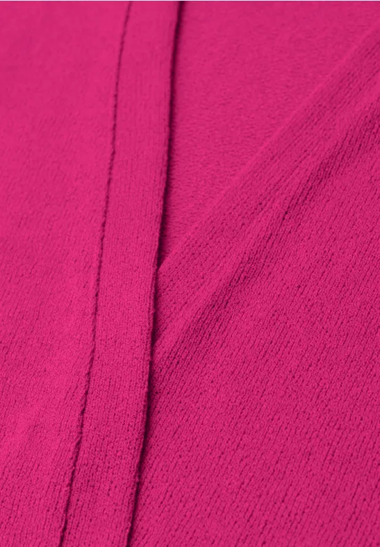 Close-up van een fuchsia roze stof met zichtbare naad.