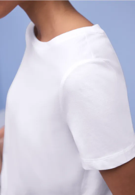 Een effen wit T-shirt gedragen door een persoon.