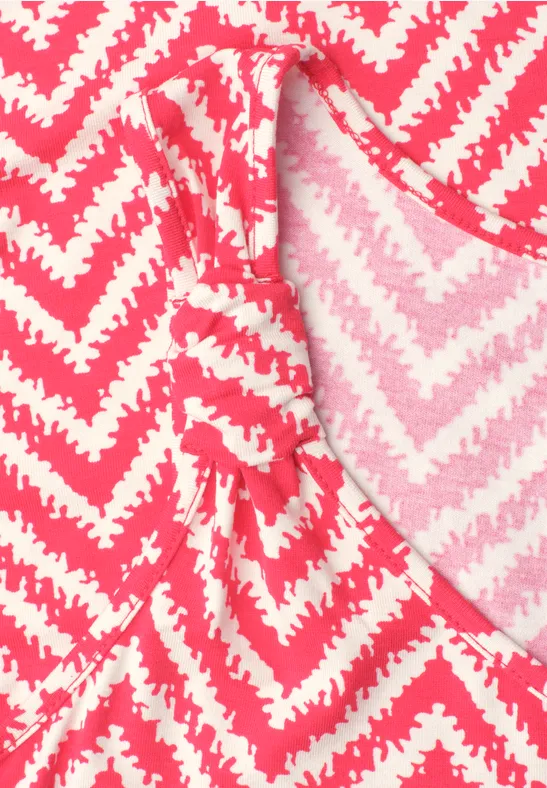 Close-up van een roze-wit zigzagpatroon op een kledingstuk
