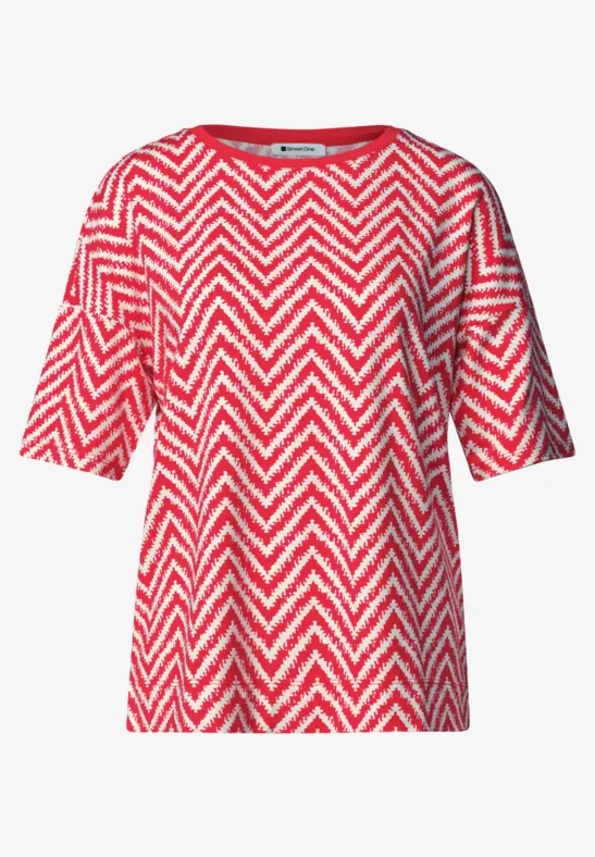 Rood T-shirt met wit zigzagpatroon en korte mouwen.