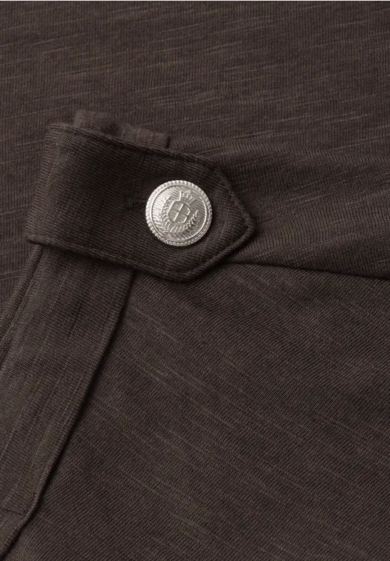 Nahaufnahme einer dunklen Stofftasche mit Klappe und silbernem Zierknopf