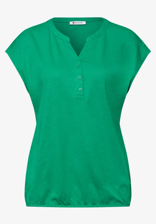 Grüne Damenbluse mit kurzem Arm, Knopfleiste und lockerem Saum.