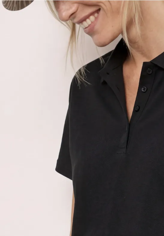 Frau lächelt in schwarzem Kurzarm-Poloshirt und Hut