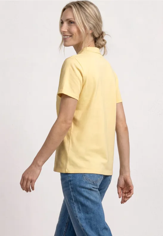 Rückenansicht einer Person in gelbem T-Shirt und blauen Jeans, entspannte Pose.
