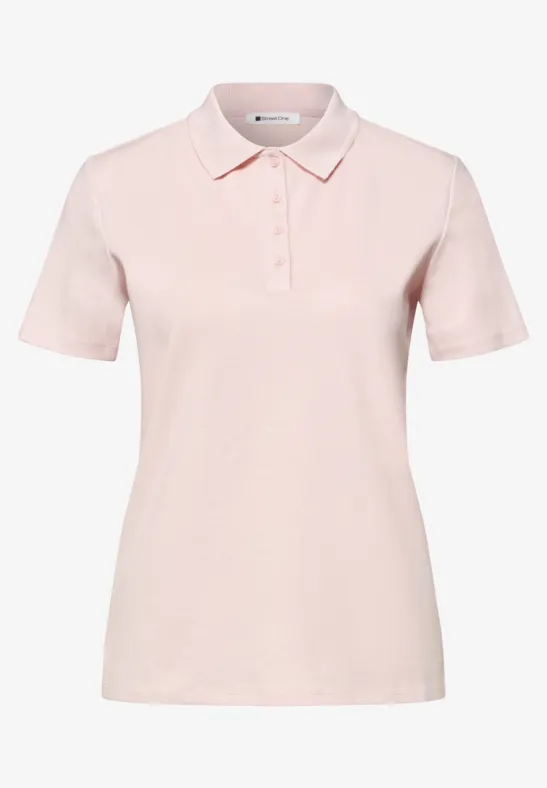 Polo femme rose pastel à manches courtes, col classique et patte de boutonnage à trois boutons.