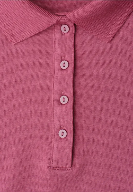 Nahaufnahme eines pinkfarbenen Poloshirts mit Kragen und Knopfleiste.