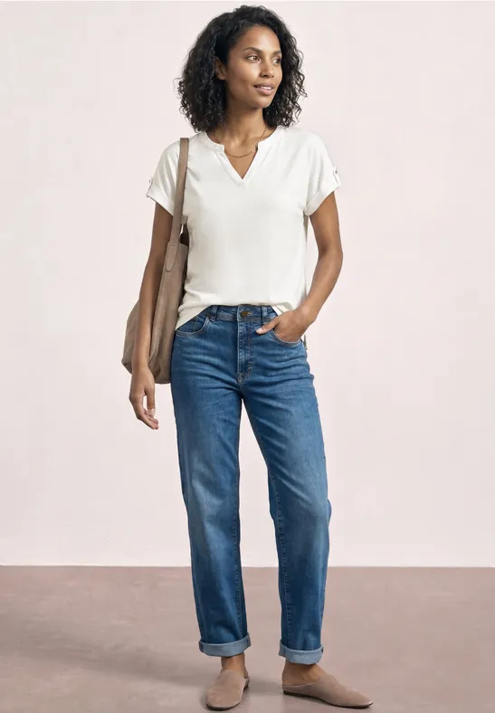 Weibliches Model mit weißem T-Shirt, Jeans und Schultertasche