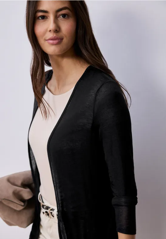 Frau im schwarzen Cardigan und beigen Top