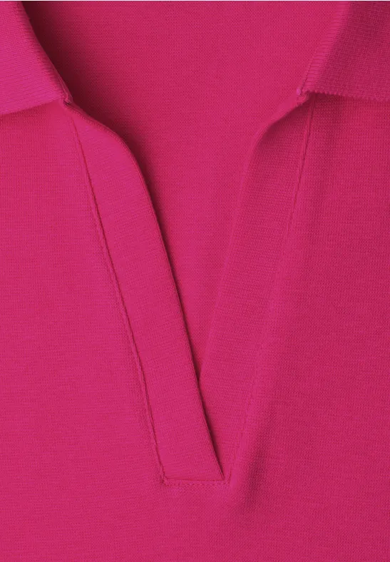Gros plan d’un polo rose vif avec col en V