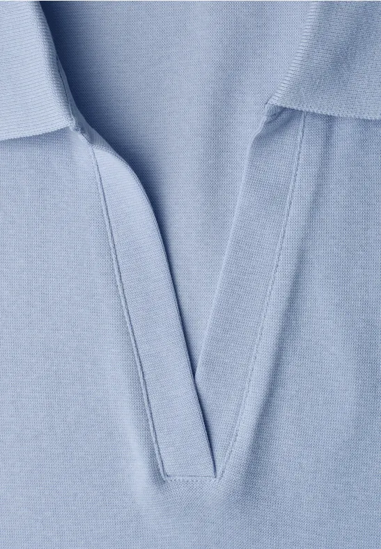 Gros plan sur un polo bleu clair avec col et ouverture en V.