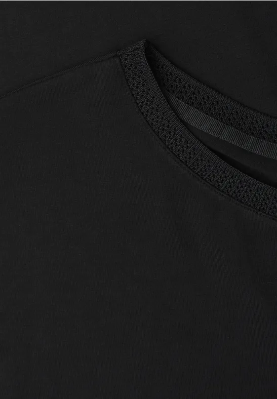 Schwarzes T-Shirt aus feinem Stoff mit Rundhalsausschnitt in Nahaufnahme.