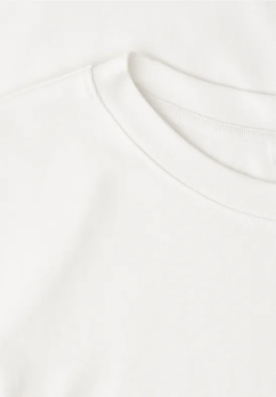 Deux T-shirts blancs superposés sur un fond clair
