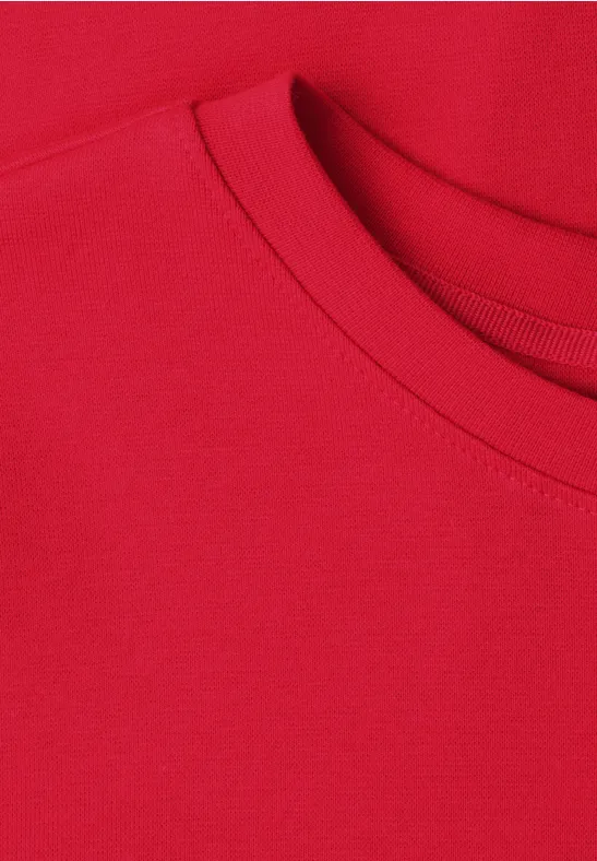 Gros plan d'un T-shirt rouge à col rond.