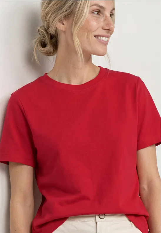 Femme en t-shirt rouge sur fond neutre