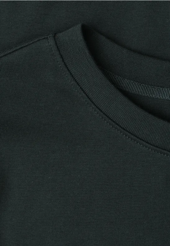 Nahaufnahme eines schwarzen T-Shirt-Ausschnitts mit sichtbarer Naht.
