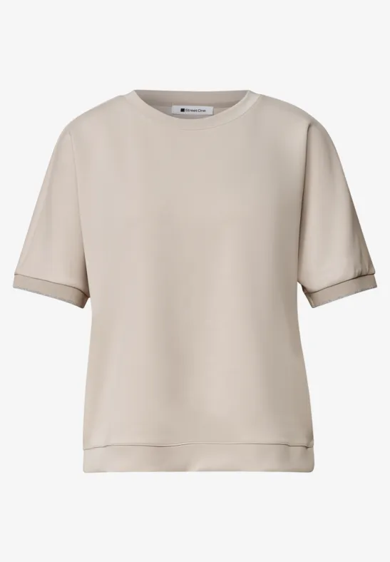 Eenvoudig, kort mouw T-shirt in licht beige, ronde hals en een iets losse pasvorm.