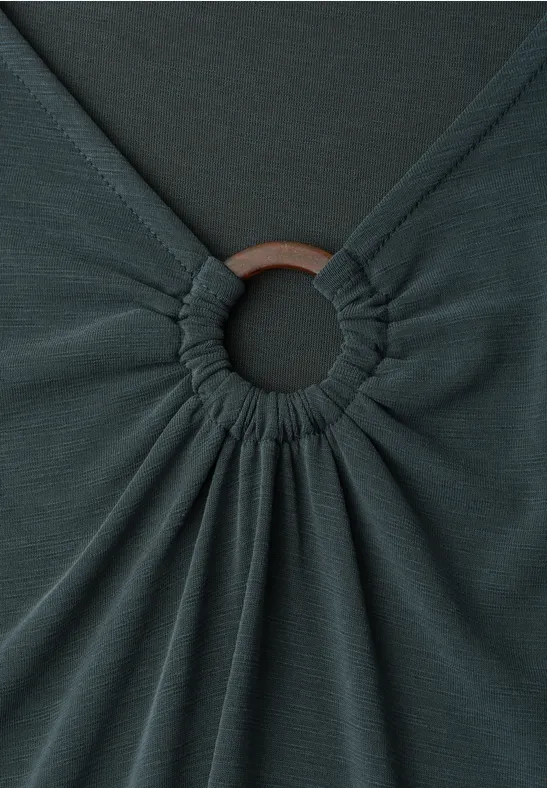 Dunkelgraues Kleidungsstück mit einem Ring, um den sich der Stoff rafft.