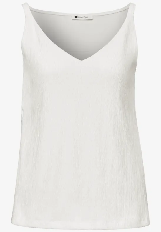Débardeur blanc sans manches à encolure V, tissu légèrement texturé.