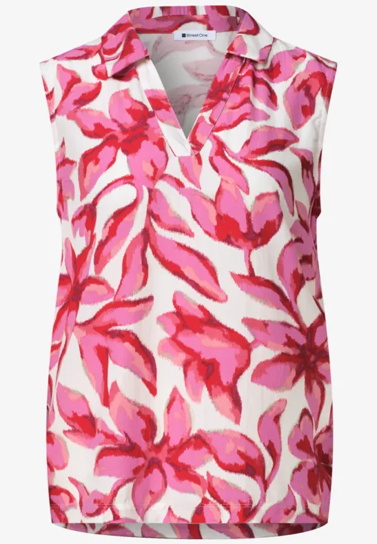Débardeur sans manches col V, fond blanc à motif floral rose vif.