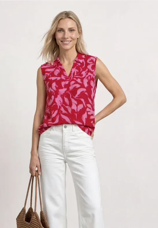 Rode mouwloze top met bloemenprint, witte broek en beige shopper.