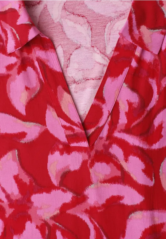 Rood bovenstuk met roze bloemenprint en V-hals.