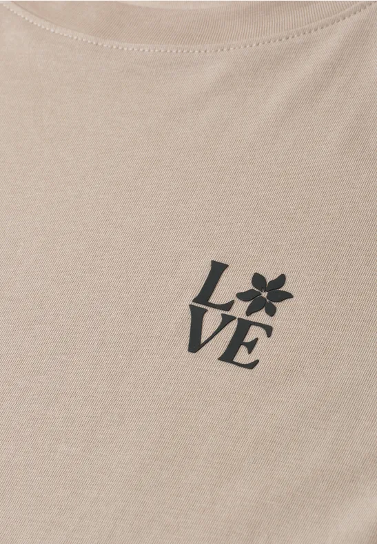 Een beige shirt met de tekst LOVE, waarbij de O is vervangen door een bloem.