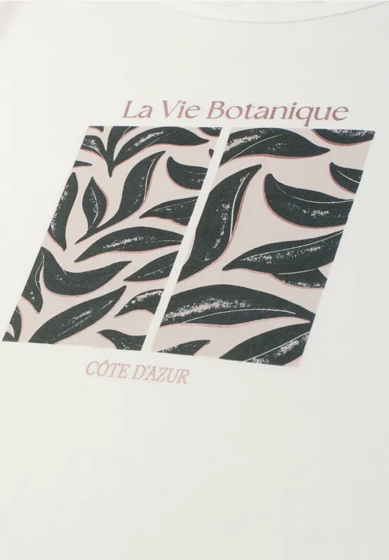 Weißes Shirt mit zwei schwarzen Flächen mit Blattmuster, Text 'La Vie Botanique' oben und 'CÔTE D'AZUR' unten.
