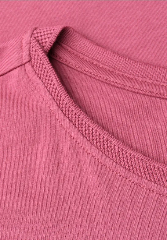 Nahaufnahme eines rosa Rundhalsausschnitts an einem T-Shirt.