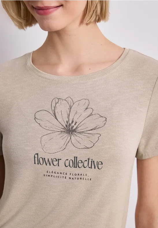 T-shirt beige avec dessin de fleur fin et inscription « flower collective ».