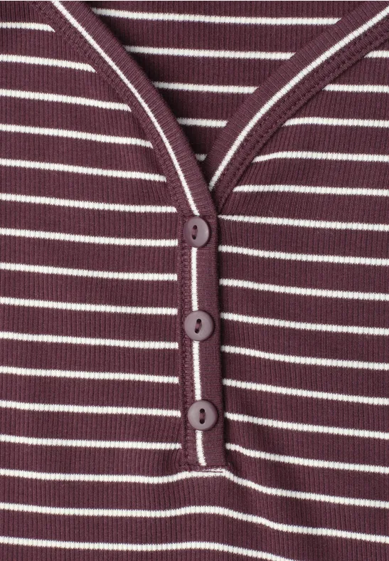 Close-up van een paars-wit gestreept shirt met knoopsluiting en drie knopen.
