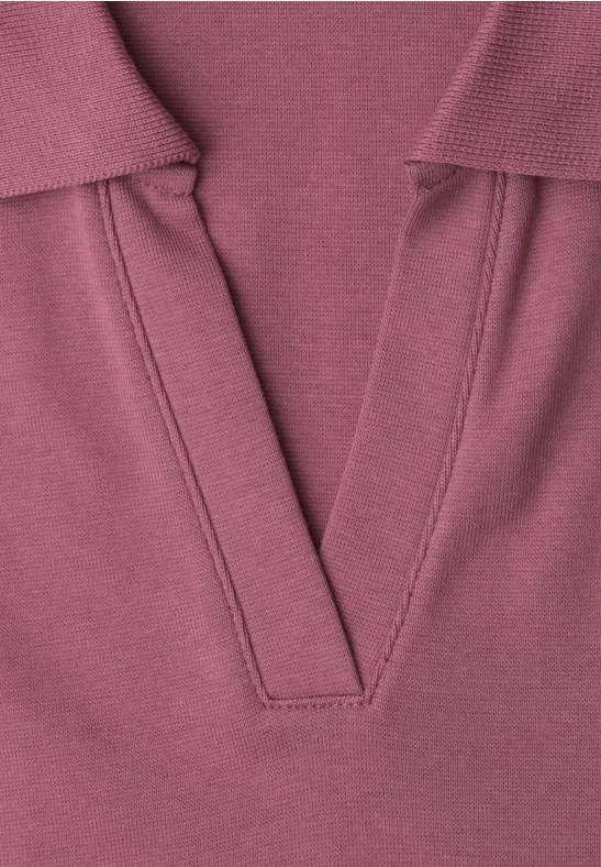Close-up van een lila gebreide top met V-hals.