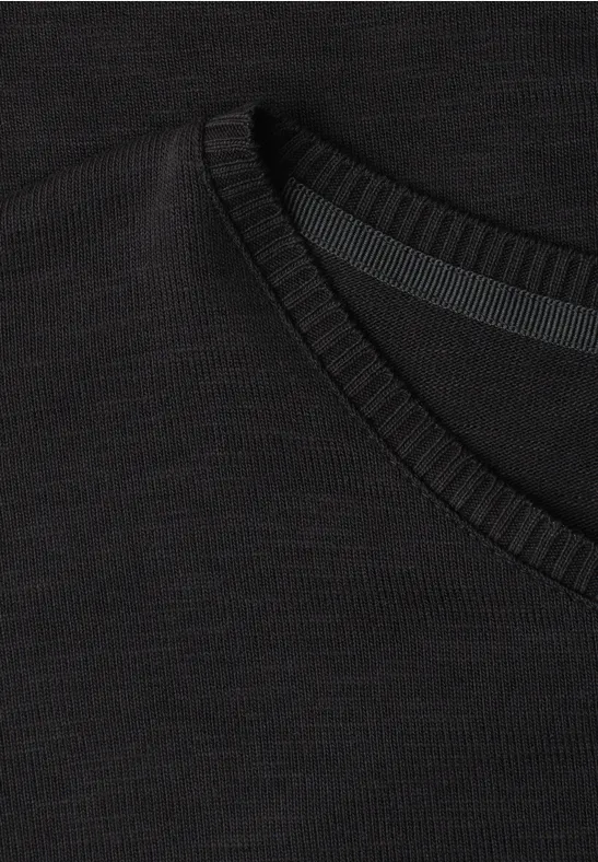 Schwarzes V-Ausschnitt-Shirt aus feinem, elastischem Strickstoff.