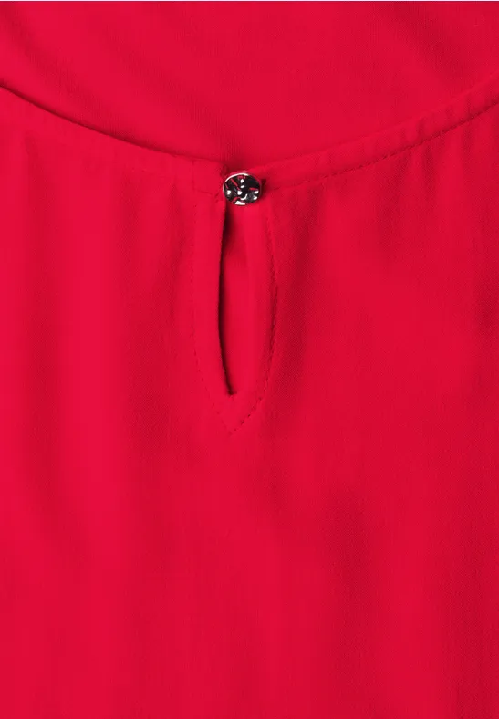 Rood mouwloos top met ronde hals en klein sierknopje voor.