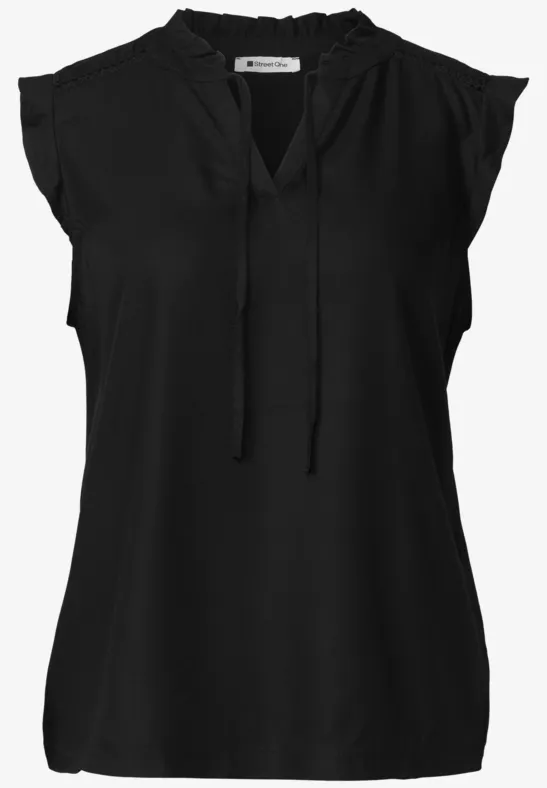 Zwarte mouwloze blouse met V-hals, koordsluiting en ruches op de schouders.