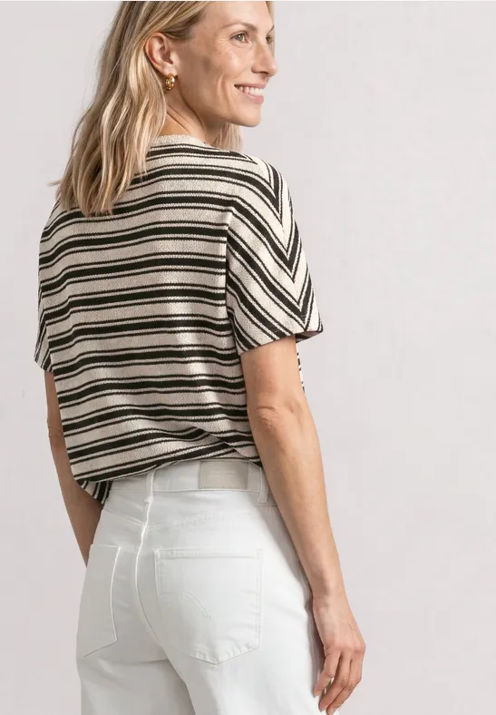 Vrouw van achteren met gestreept T-shirt en witte spijkerbroek