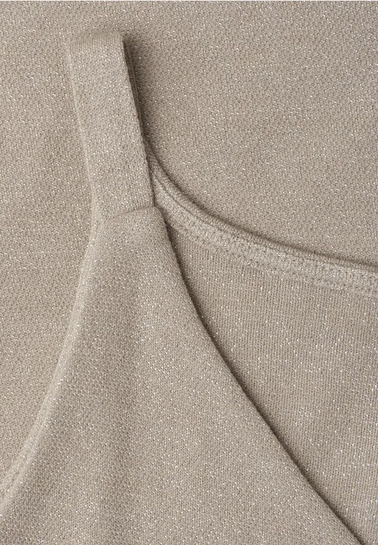 Close-up van een beige, glinsterende spaghetti-top.