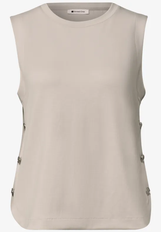Mouwloos beige top met ronde hals en knoopsluiting aan de zijkanten.