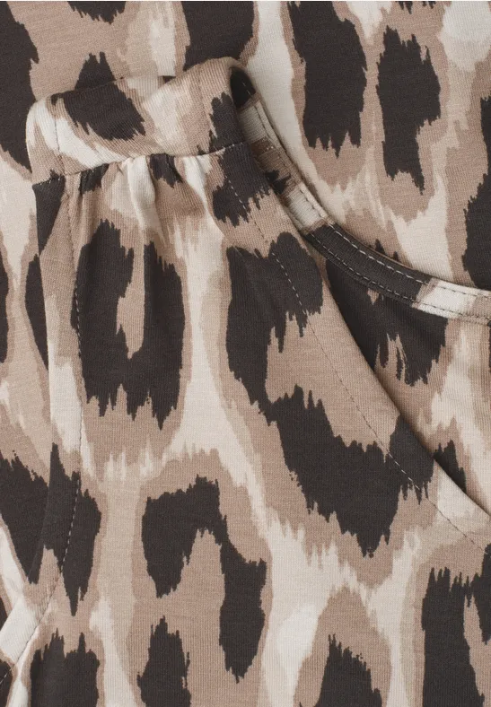 Close-up van beige-bruin luipaardprint stof met stiksel en zakrand.